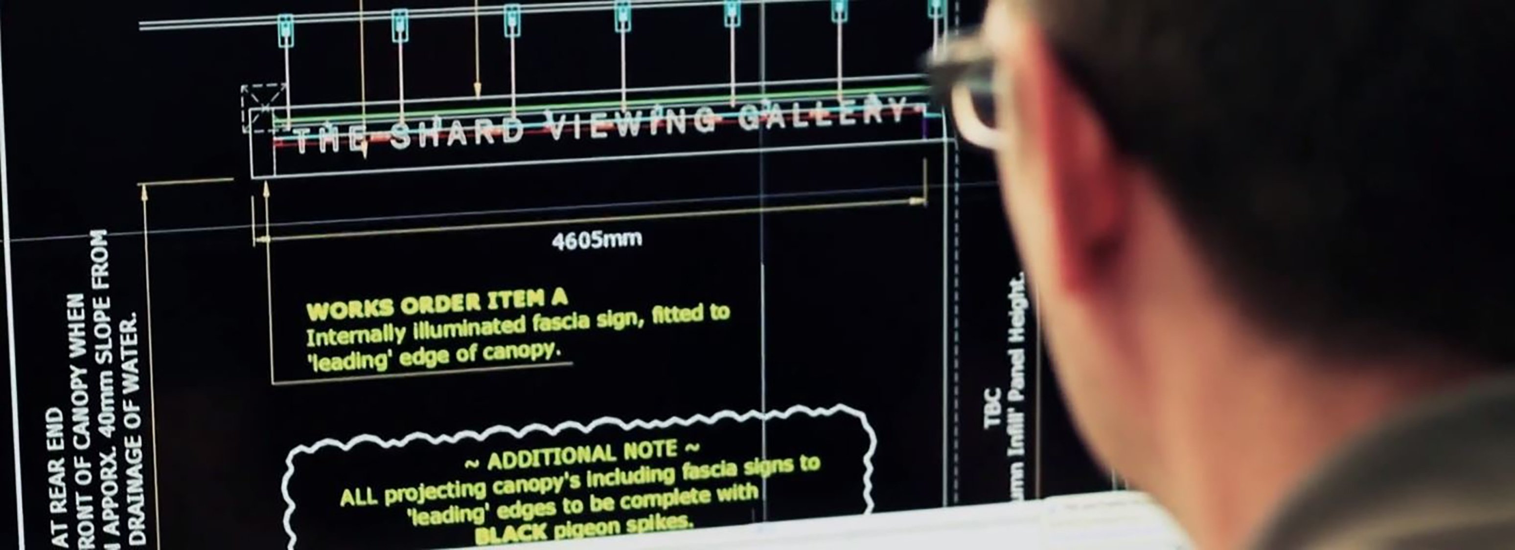 A man digitally creating commercial signage on a screen